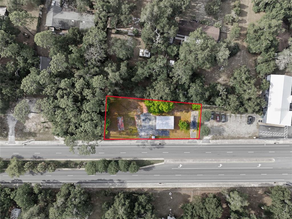 An aerial view shows a rectangular lot with a small building bordered by a road — 320 HIGHWAY 466, LADY LAKE, FL
