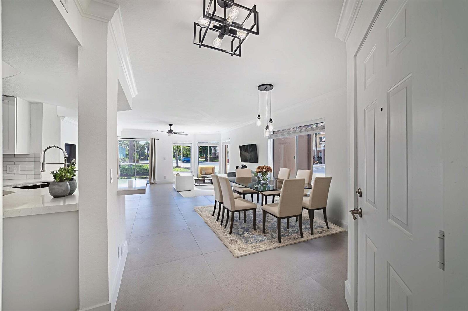 A bright open-concept dining and living area features tile flooring, modern lighting, and neutral furniture — 815 W Boynton Beach Boulevard # 106, Boynton Beach FL 33426, BOYNTON BEACH, FL