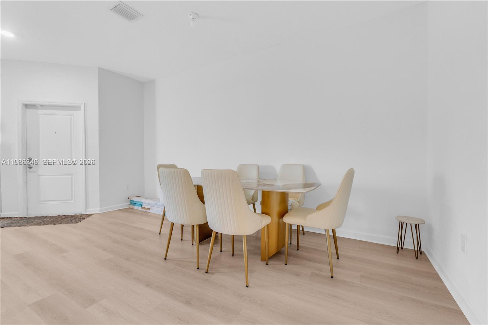 A dining area features a marble-topped table with gold base and six cream-colored chairs — 21068 NE 8th Ave, Miami FL 33179, MIAMI, FL