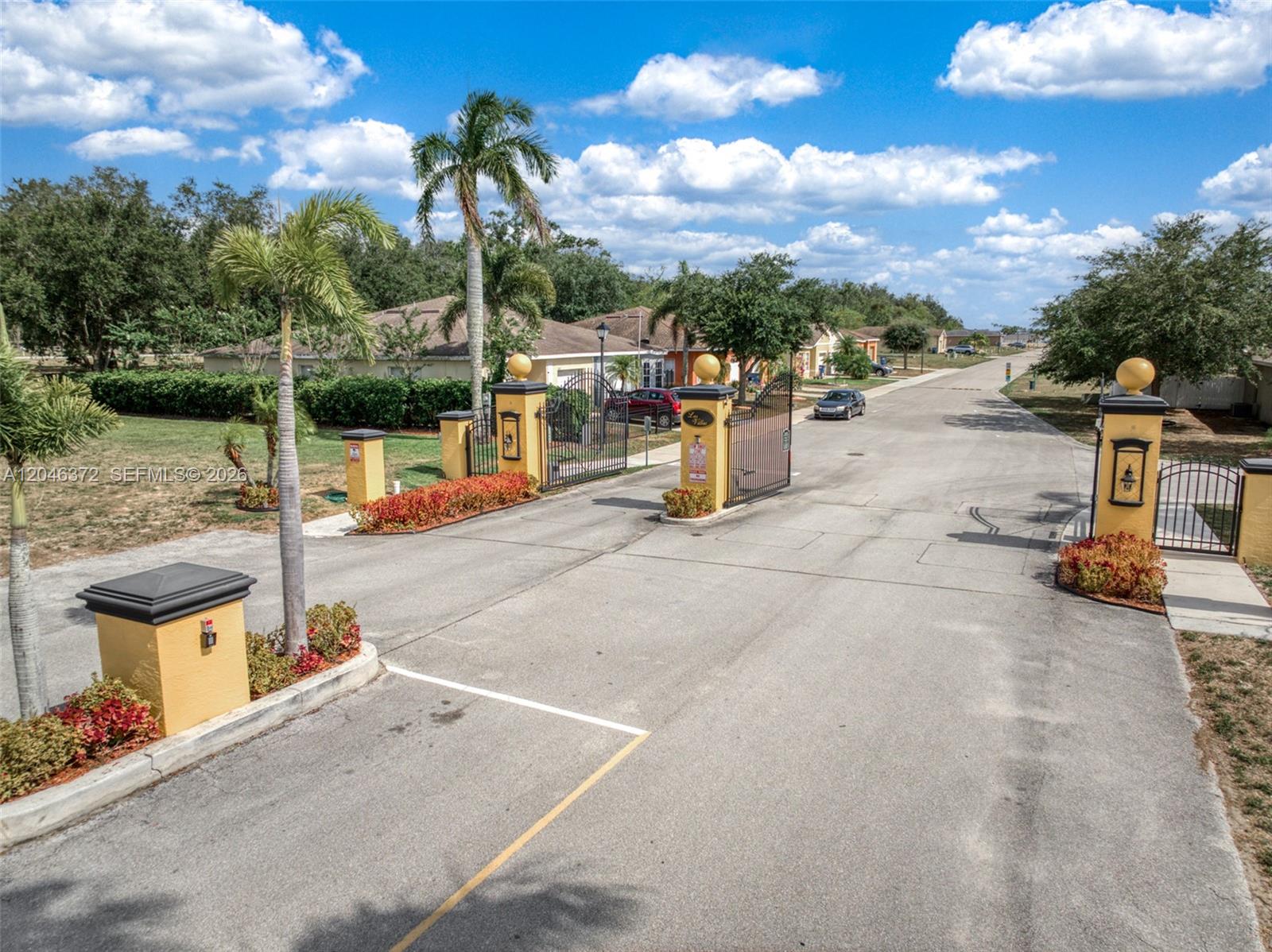 An aerial view shows the gated entrance to a residential community with paved roads — 1428 Las Villas Blvd, Sebring FL 33870, SEBRING, FL
