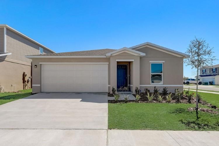 A single-story suburban house features a two-car garage, a blue front door, and a driveway — 3244 E ODIER STREET, INVERNESS, FL