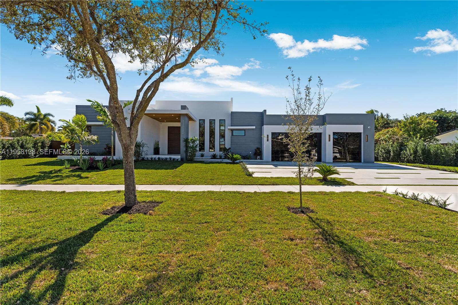 A modern single-story house with a flat roof, gray and white exterior, and two garages — 11000 SW 120th St, Miami FL 33176, MIAMI, FL
