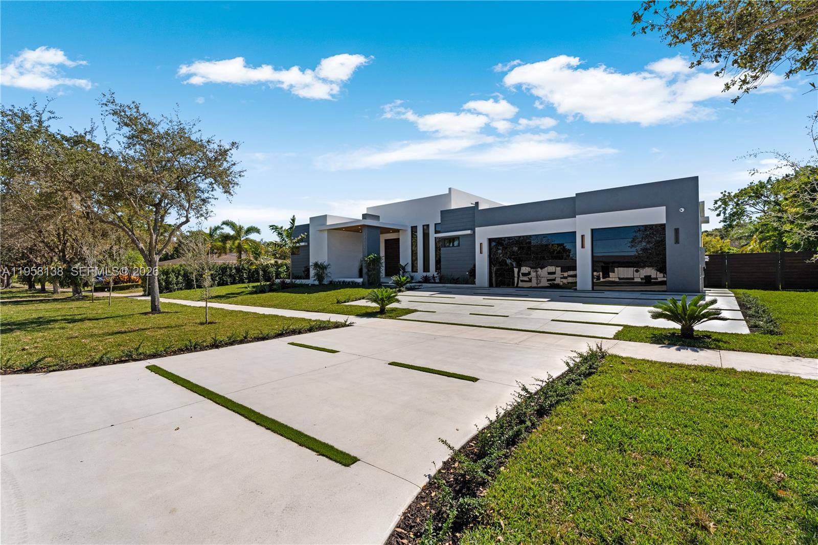 A modern single-story house features a concrete driveway with grass strips and a two-car garage — 11000 SW 120th St, Miami FL 33176, MIAMI, FL