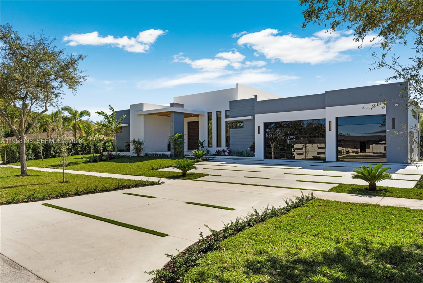 A modern single-story house features a gray and white exterior with a multi-car garage — 11000 SW 120th St, Miami FL 33176, MIAMI, FL