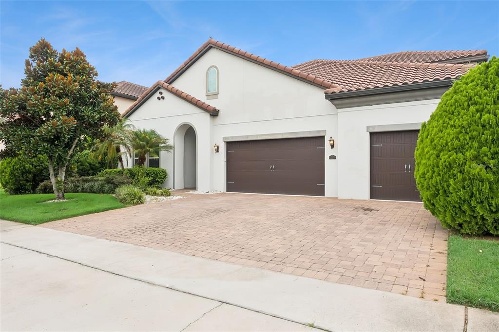 A single-story house with a tiled roof, two garage doors, and a paved driveway — 10370 DOTH STREET, ORLANDO, FL
