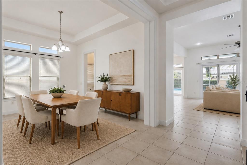 A dining room with a wooden table and chairs sits adjacent to a living area — 10370 DOTH STREET, ORLANDO, FL