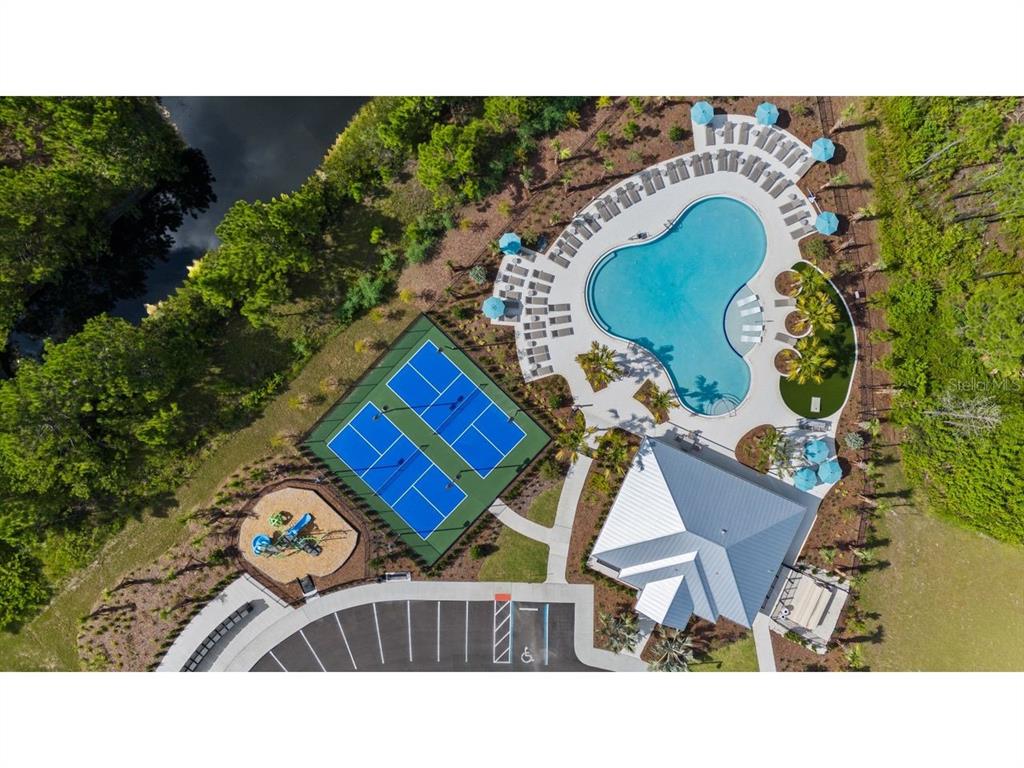 An aerial view shows a swimming pool, tennis courts, playground, and clubhouse with parking — 14 GARNI DRIVE, PALM COAST, FL
