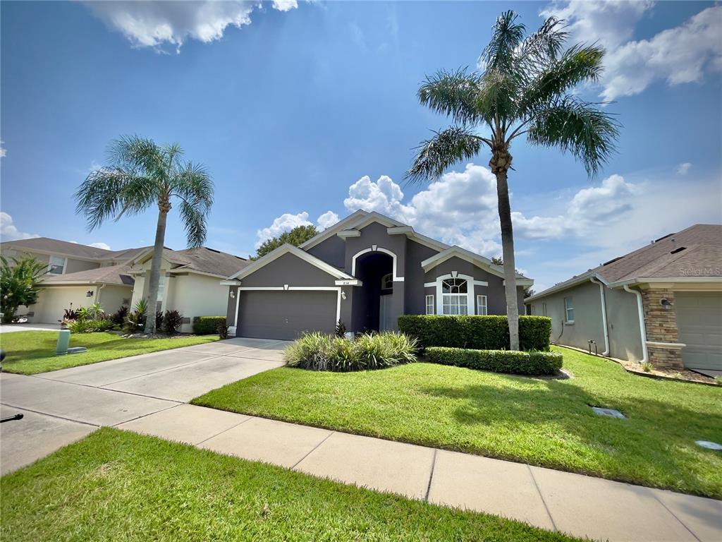 A dark gray single-story house features a two-car garage and two tall palm trees — 834 SENECA MEADOWS ROAD, WINTER SPRINGS, FL