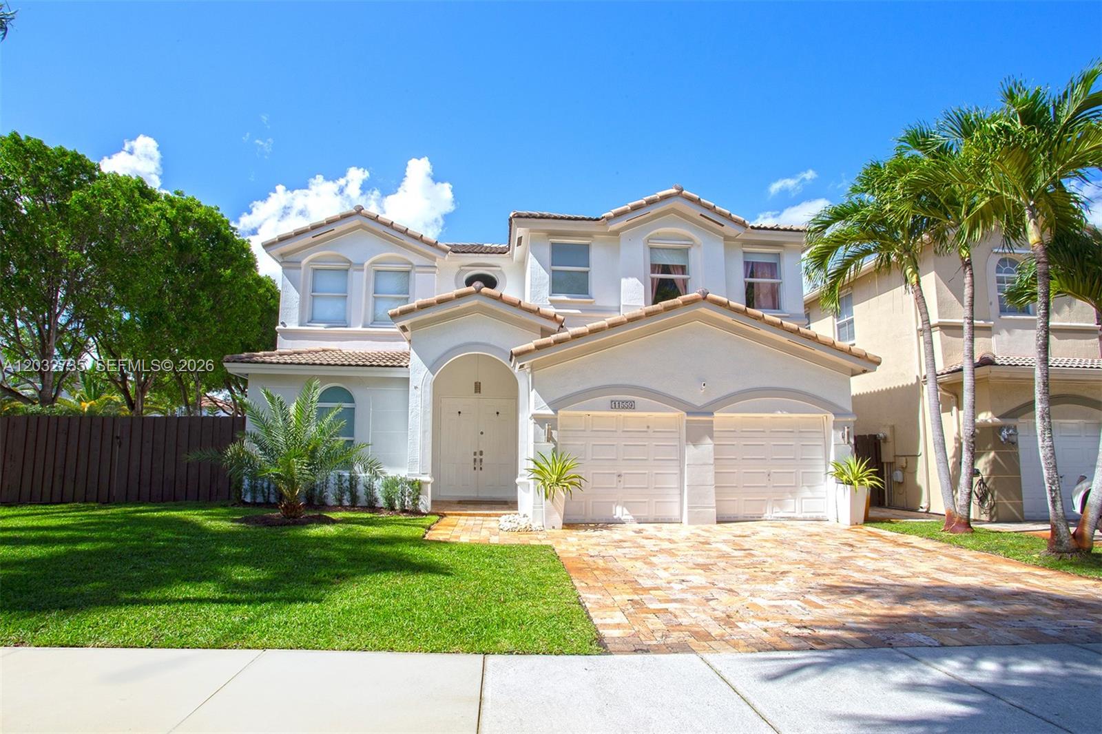 A two-story suburban house with a tiled roof, white stucco exterior, and a paved driveway — 11559 NW 84th Ter, Doral FL 33178, DORAL, FL