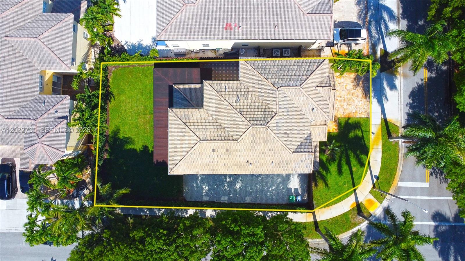 An aerial view shows a residential property with a tiled roof, lawn, and paved driveway — 11559 NW 84th Ter, Doral FL 33178, DORAL, FL