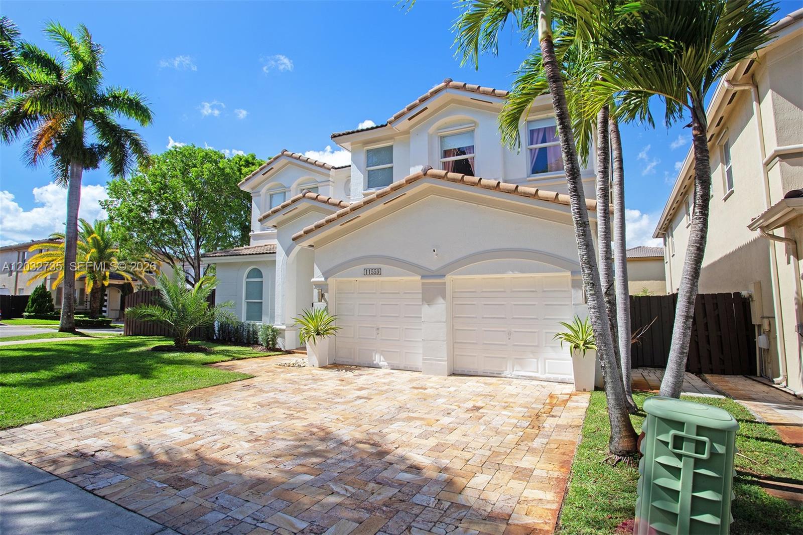 A two-story house with a paved driveway, two-car garage, and palm trees in the front — 11559 NW 84th Ter, Doral FL 33178, DORAL, FL