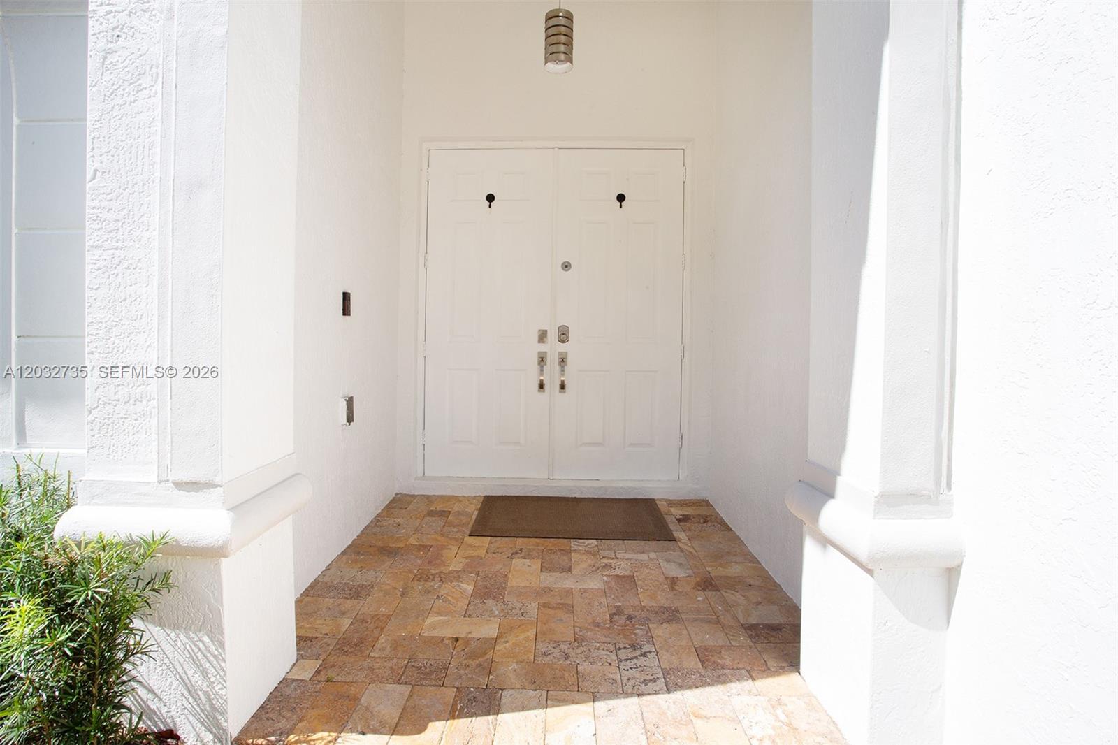 A white double front door opens onto a stone-tiled entryway under a covered porch — 11559 NW 84th Ter, Doral FL 33178, DORAL, FL