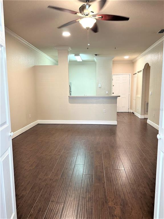 An open living area features dark wood-look flooring, a ceiling fan, and a kitchen pass-through — 3355 S KIRKMAN ROAD UNIT 1315, ORLANDO, FL