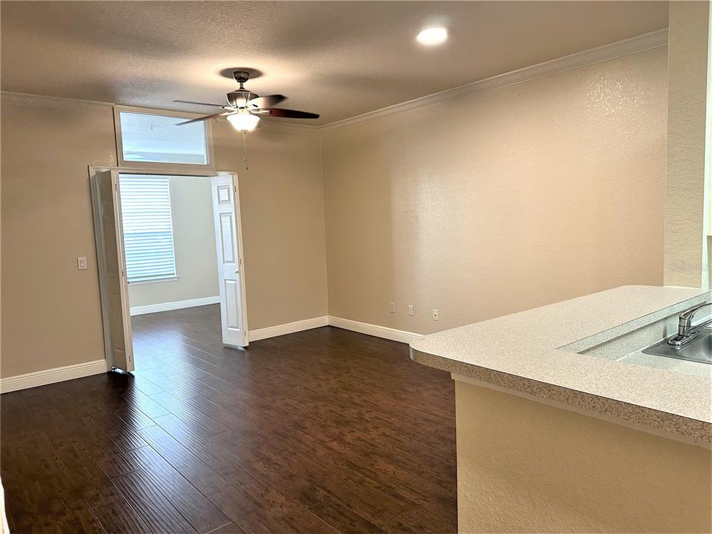 A room with dark wood flooring, a ceiling fan, and double doors leading to another room — 3355 S KIRKMAN ROAD UNIT 1315, ORLANDO, FL