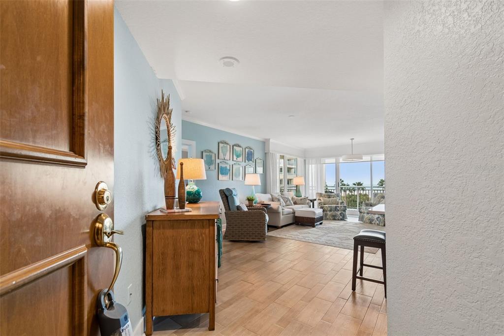 A view from an open doorway into a living room with tile floors and balcony — 1170 GULF BOULEVARD UNIT 403, CLEARWATER BEACH, FL