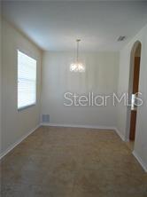 A dining area with tile flooring, a window with blinds, and a hanging light fixture — 11339 VILLAGE BROOK DRIVE, RIVERVIEW, FL