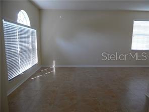 An empty room with beige walls, tile flooring, and two windows with white blinds — 11339 VILLAGE BROOK DRIVE, RIVERVIEW, FL