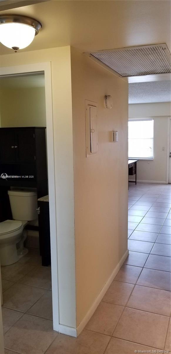 A view from a hallway looking into a bathroom and an adjacent tiled living area — 366 Fanshaw I # 366, Boca Raton FL 33434, BOCA RATON, FL