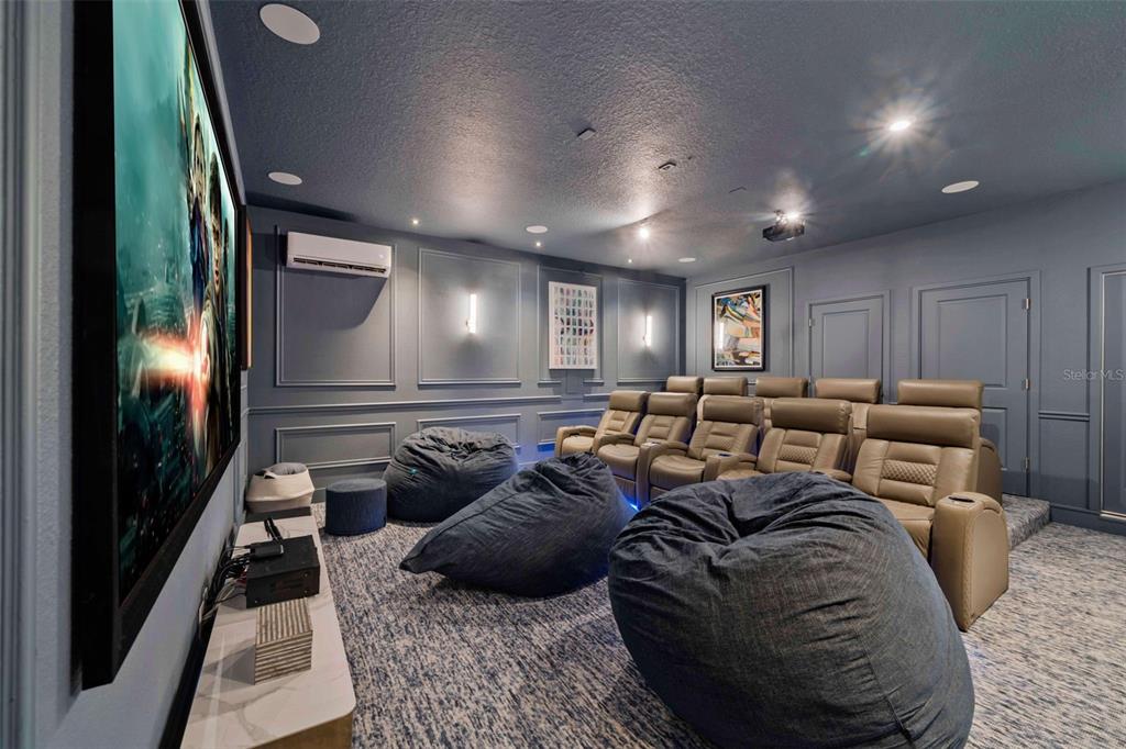 A home theater features a large screen, rows of seating, beanbag chairs, and blue walls — 9127 TURQUOISE WAVE COVE, KISSIMMEE, FL