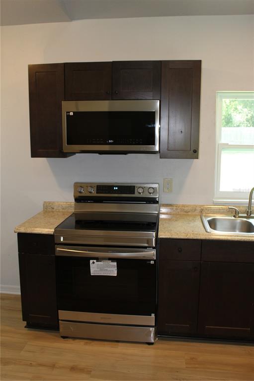 A kitchen features dark wood cabinets, stainless steel appliances, and light-colored laminate countertops — 11413 PRUETT ROAD, SEFFNER, FL