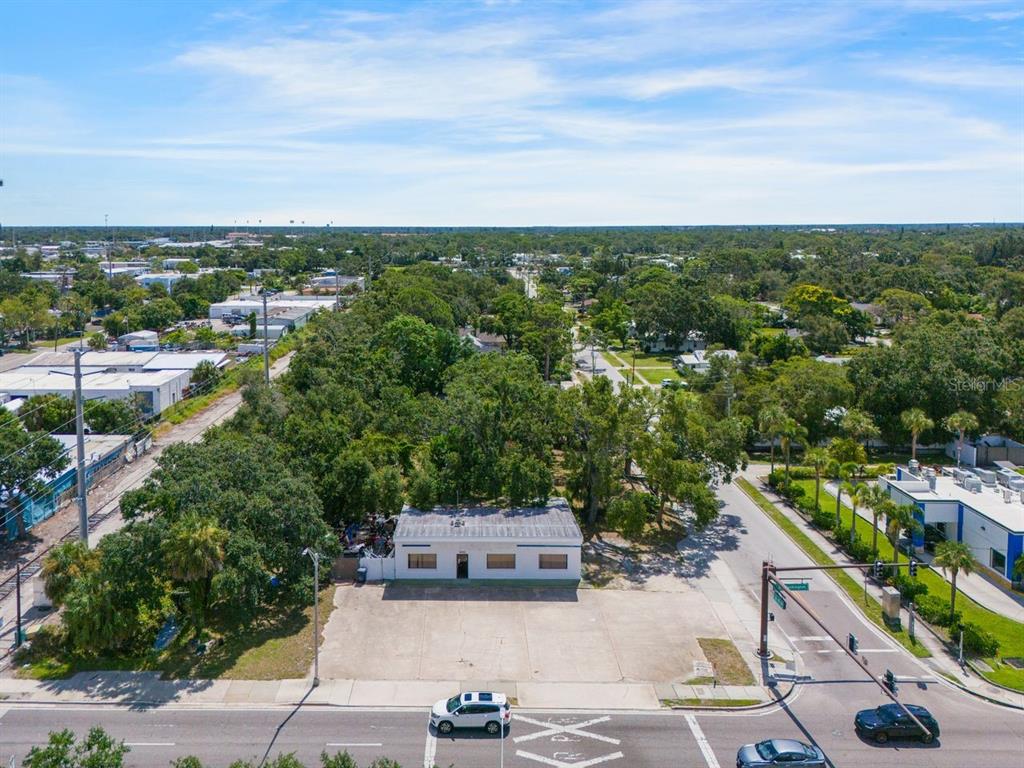 An aerial view shows a single-story building with a large paved parking lot in front — 1000 N WASHINGTON BOULEVARD, SARASOTA, FL