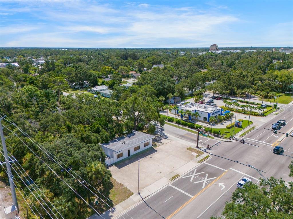 An aerial view shows a small commercial building on a corner lot near a road — 1000 N WASHINGTON BOULEVARD, SARASOTA, FL