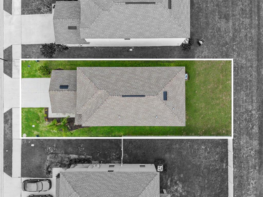 An aerial view shows a single-family home with a shingled roof and a fenced backyard — 36420 GARDEN WALL WAY, ZEPHYRHILLS, FL
