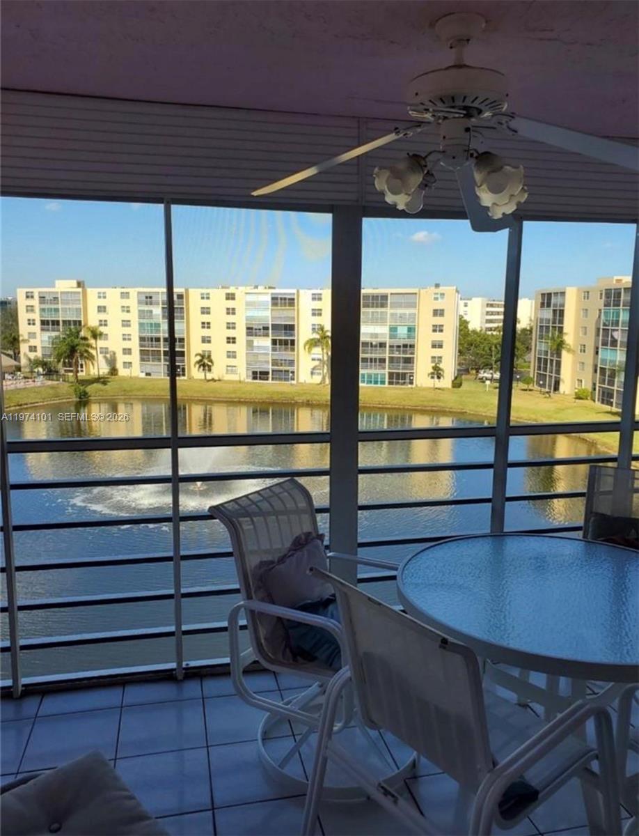 A screened-in balcony overlooks a pond and apartment buildings with a fountain in the center — 441 SE 3rd St # 505, Dania Beach FL 33004, DANIA BEACH, FL