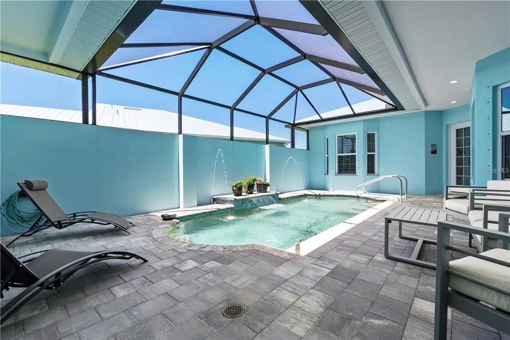 A screened-in patio features a small swimming pool with a waterfall and lounge chairs — 10391 COQUINA COURT, PLACIDA, FL