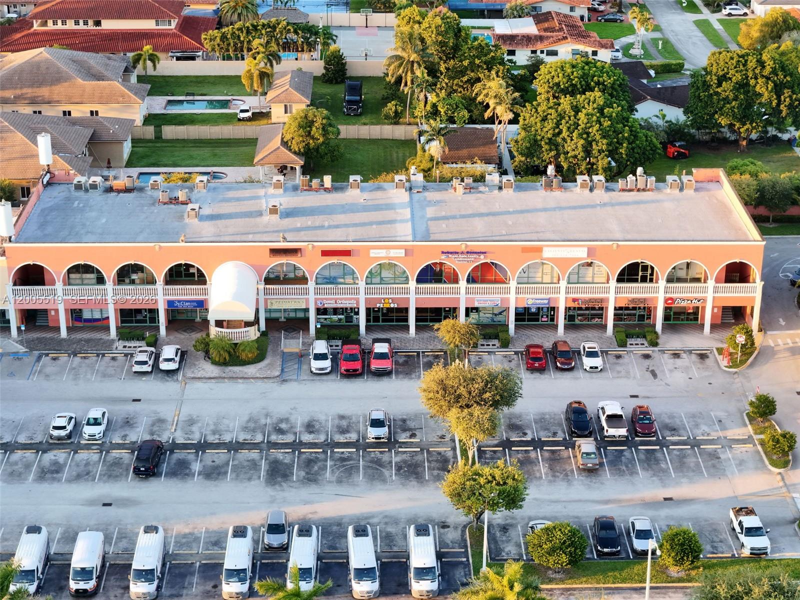 An aerial view shows a commercial strip mall with a parking lot and surrounding trees — 12711 SW 42nd St, Miami FL 33175, MIAMI, FL