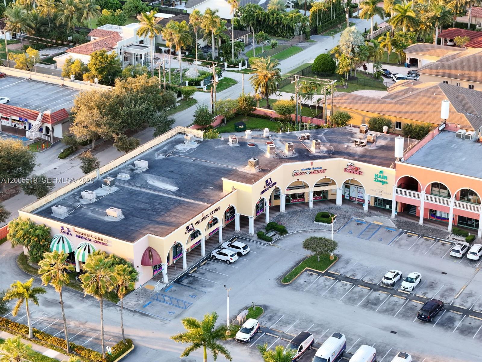 An aerial view of a commercial strip mall with a parking lot and palm trees — 12711 SW 42nd St, Miami FL 33175, MIAMI, FL