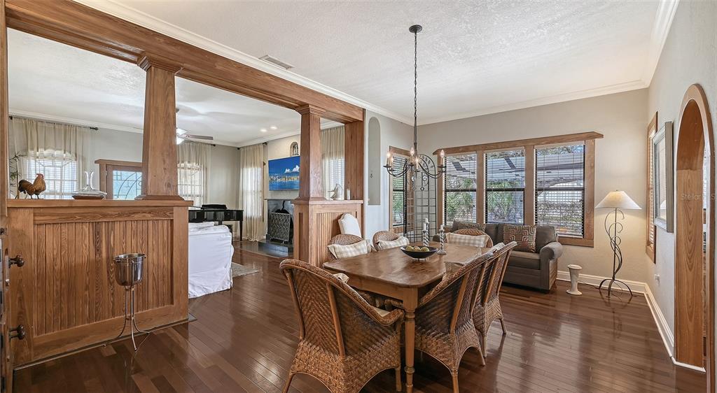 A dining room with a wooden table, wicker chairs, and a view into the living area — 1563 4TH STREET, SARASOTA, FL