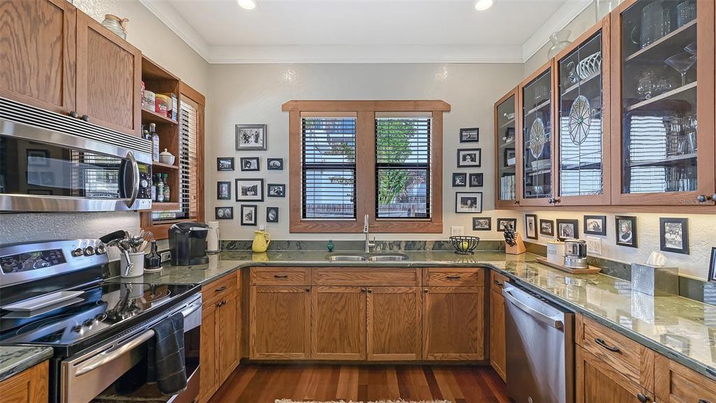 A kitchen features wood cabinets, green countertops, stainless steel appliances, and a window above the sink — 1563 4TH STREET, SARASOTA, FL