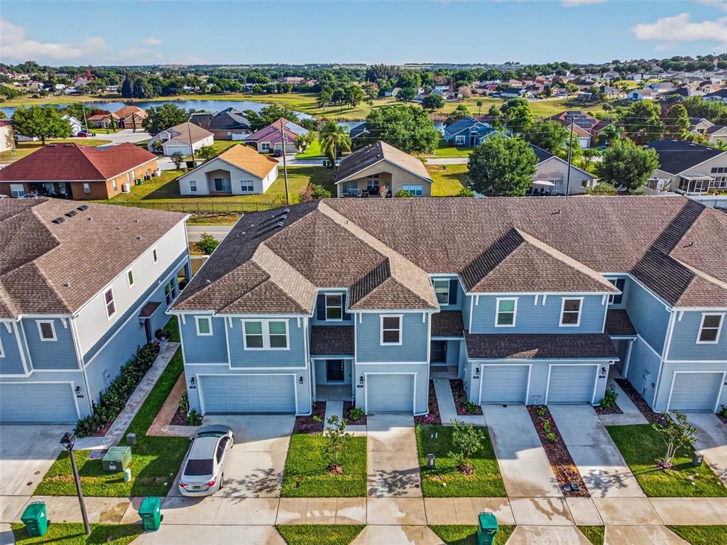 An aerial view shows a row of blue townhouses with attached garages and driveways — 391 SOL VISTA DRIVE, DUNDEE, FL