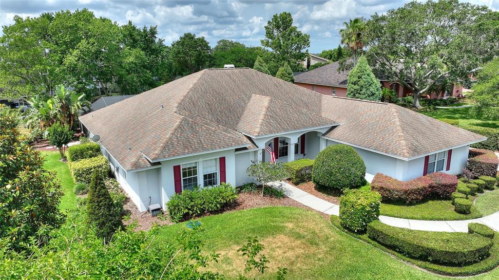 An aerial view of a single-story house with a shingled roof and red shutters — 5521 EMERALD RIDGE BOULEVARD, LAKELAND, FL