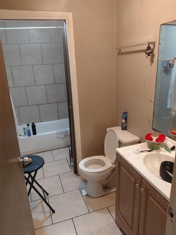 A bathroom features a vanity, a toilet, and a tiled shower-tub combination — 1903 E 23RD AVENUE, TAMPA, FL