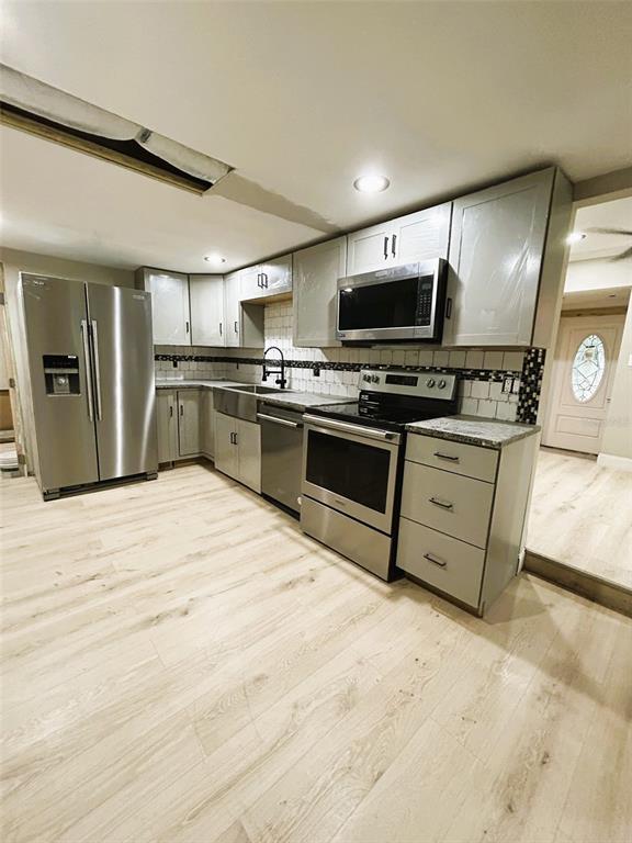 A kitchen features light gray cabinets, stainless steel appliances, and light wood-look flooring — 2310 21ST STREET S, ST PETERSBURG, FL