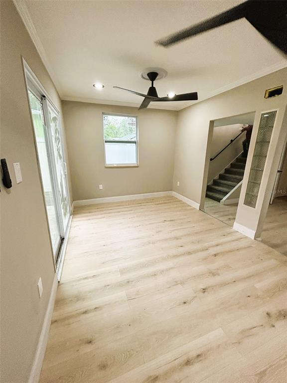 A room with light wood-look flooring, a ceiling fan, a window, and a sliding door — 2310 21ST STREET S, ST PETERSBURG, FL