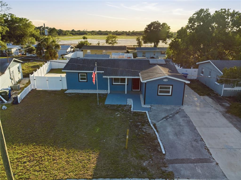 An aerial view of a blue single-story house with a concrete driveway and fenced yard — 12760 118TH STREET, LARGO, FL