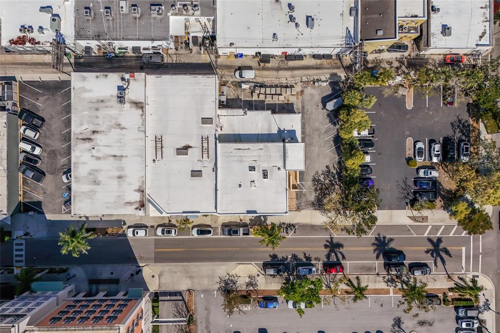 An aerial view shows a commercial building with a parking lot and street parking — 1565 STATE STREET, SARASOTA, FL
