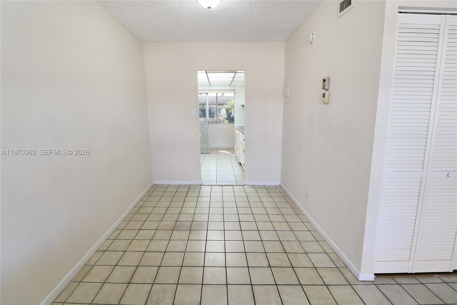A tiled dining area leads through a doorway into a kitchen with a window — 601 NW 78th Ter # 204, Margate FL 33063, MARGATE, FL