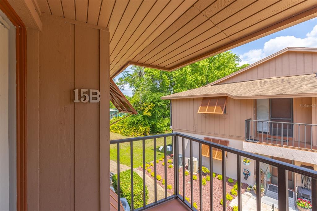 A view from a second-story balcony overlooking a courtyard and another residential building — 180 MAGNOLIA WOODS COURT UNIT 15B, DELTONA, FL