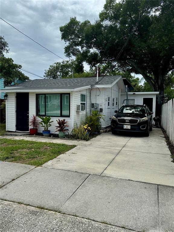 A white single-story house with a black front door and a driveway featuring a car — 602 S PROSPECT AVENUE, CLEARWATER, FL
