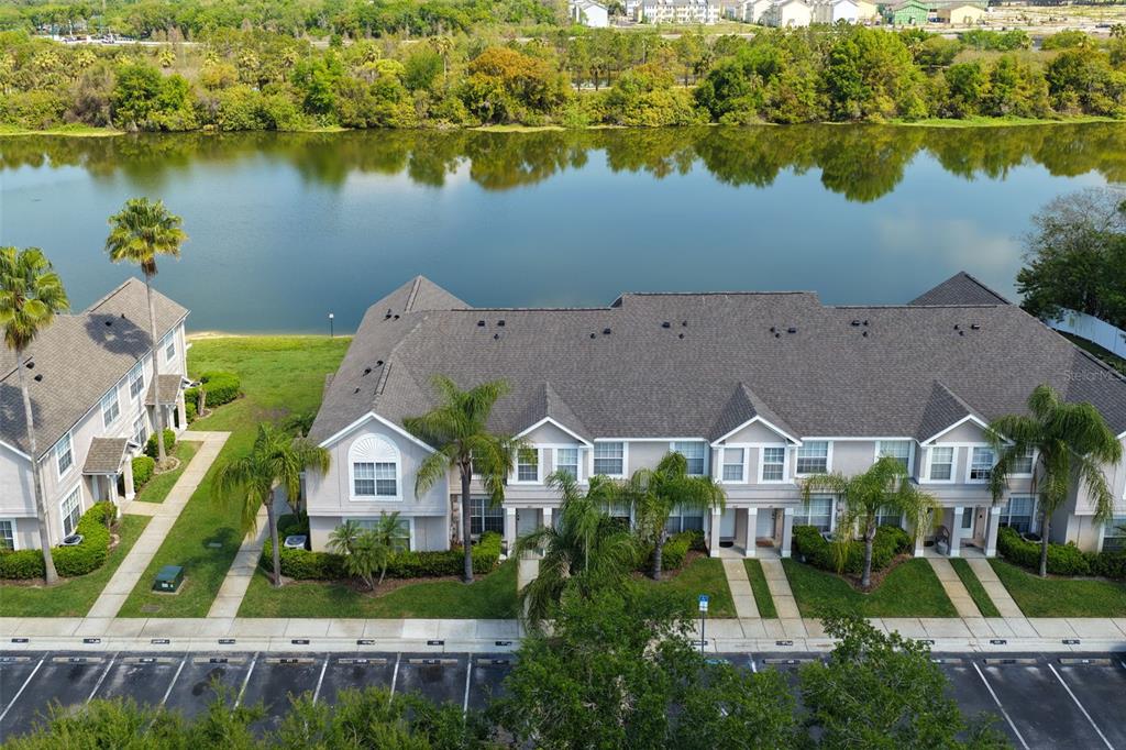 A two-story tan townhouse exterior features palm trees, a sidewalk, and numbered parking spaces — 425 KENSINGTON LAKE CIRCLE, BRANDON, FL
