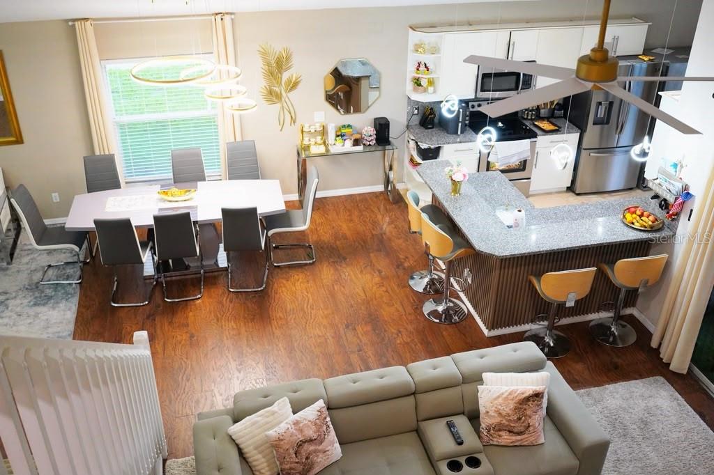 An elevated view of an open-concept living area featuring a kitchen, dining space, and sofa — 2592 CHATHAM CIRCLE, KISSIMMEE, FL