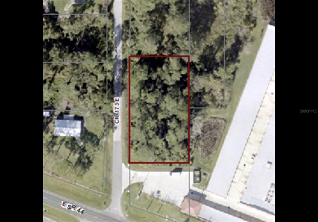 An aerial map view shows a rectangular, wooded lot outlined in red near a road intersection — CR 173E, WILDWOOD, FL