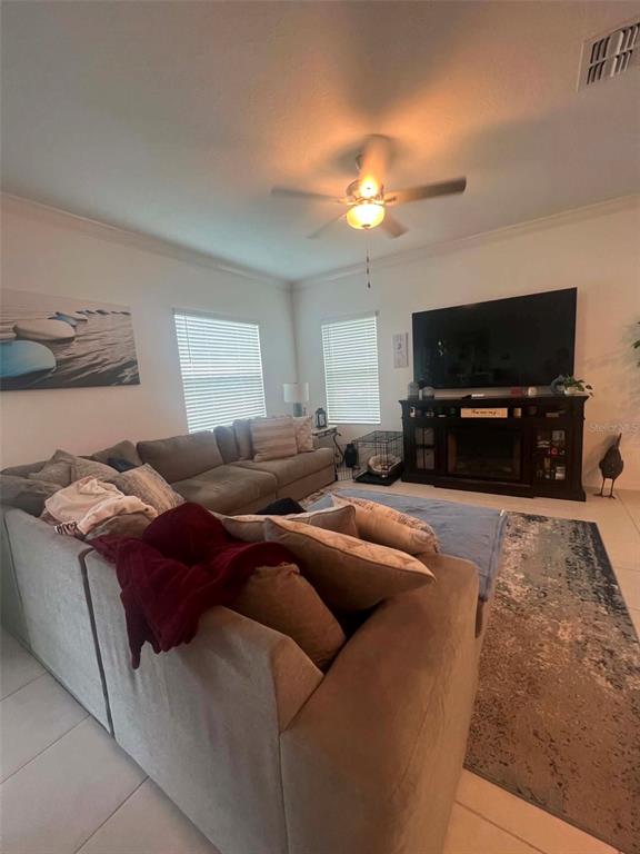 A living room features a large sectional sofa, a ceiling fan, and a media console — 8845 GALLANTREE PLACE, LAND O LAKES, FL