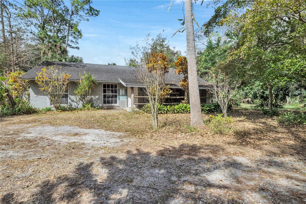 A single-story house with a gray exterior sits on a lot surrounded by trees — 14181 35TH PLACE N, LOXAHATCHEE, FL