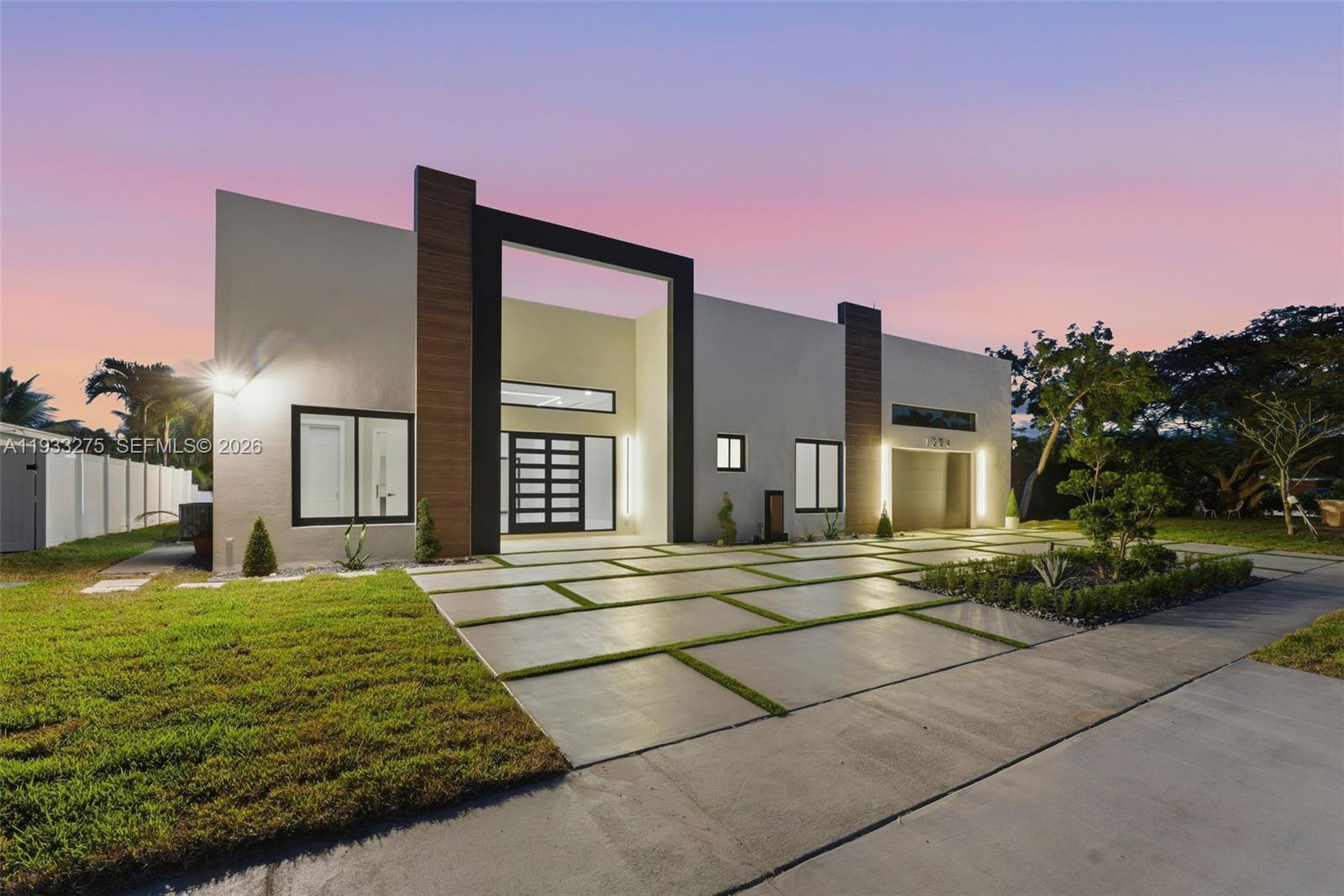 A modern single-story house features a concrete paver driveway and a prominent black entryway frame — 1304 SE 10th Ter, Deerfield Beach FL 33441, DEERFIELD BEACH, FL