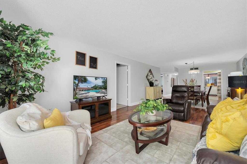 A living room features hardwood floors, a neutral area rug, and a brown leather recliner — 2612 PEARCE DRIVE UNIT 310, CLEARWATER, FL